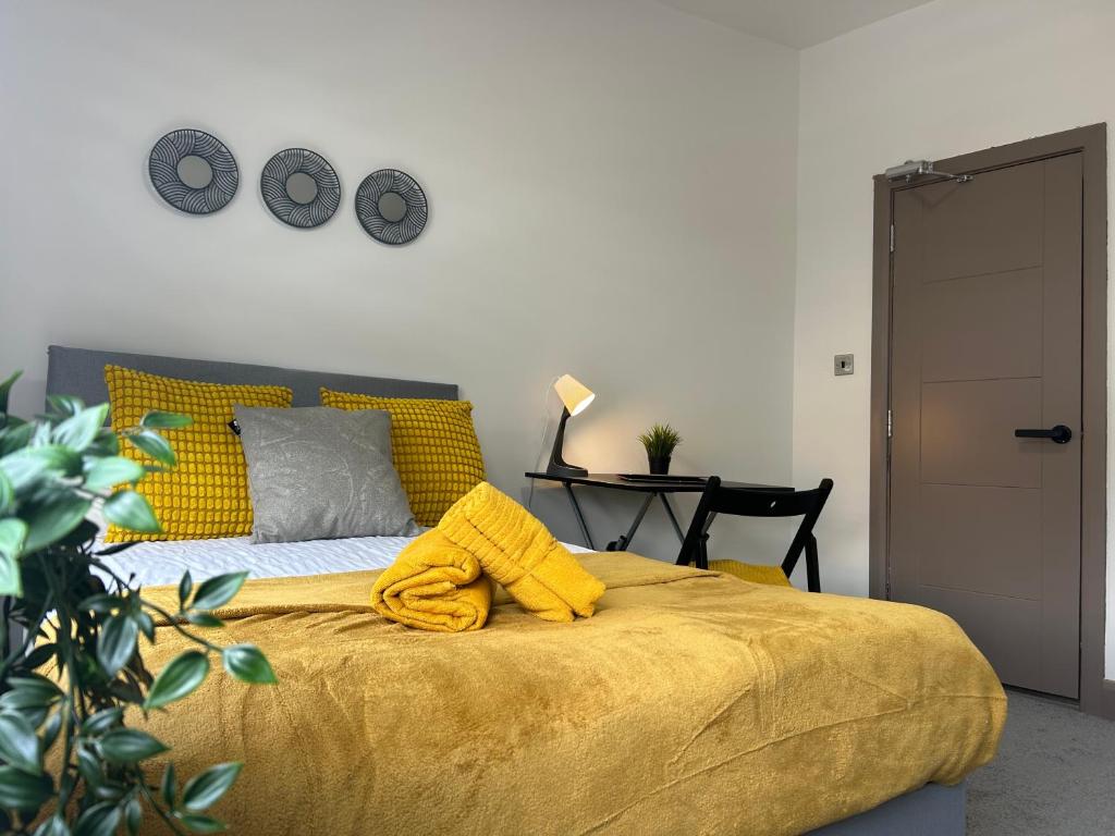 a bedroom with a bed with a yellow blanket on it at S5 Private Ensuite Room for Professionals AND contractors LNG Grain digs in Gillingham