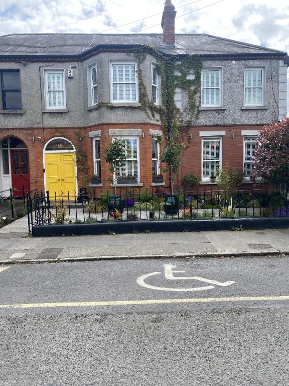 a house with a yellow door on the side of the road at Avoca House in Dublin