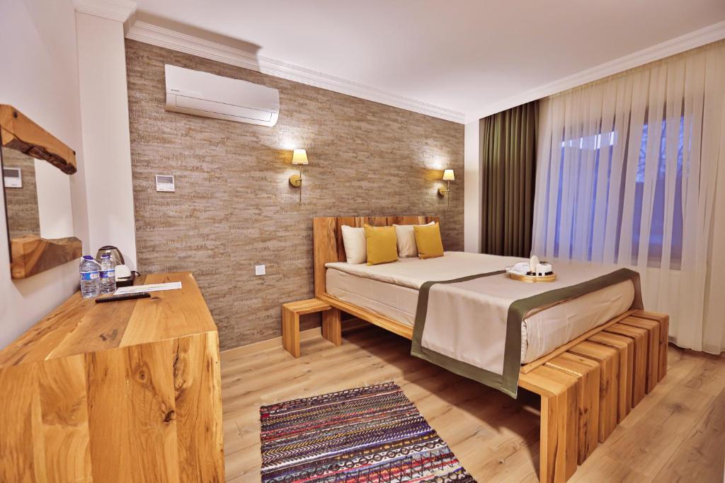 a bedroom with a large bed and a brick wall at Livadi Jur in Akçakoca