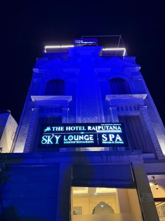 a building with a blue lit up sign on it at Hotel The Rajputana Ranthambore in Sawāi Mādhopur