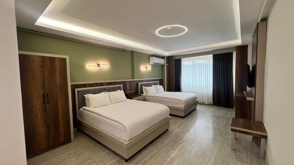 a hotel room with two beds and a television at Samsun Airport Resort Hotel in Samsun