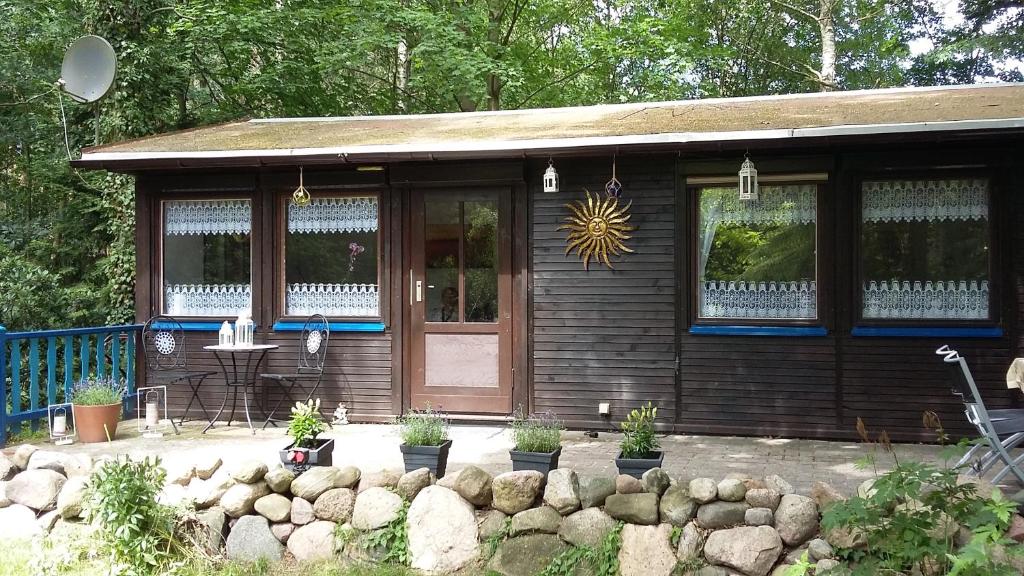 ein kleines Holzhaus mit Pflanzen davor in der Unterkunft Ferienidyll Alte Eichen in Storkow