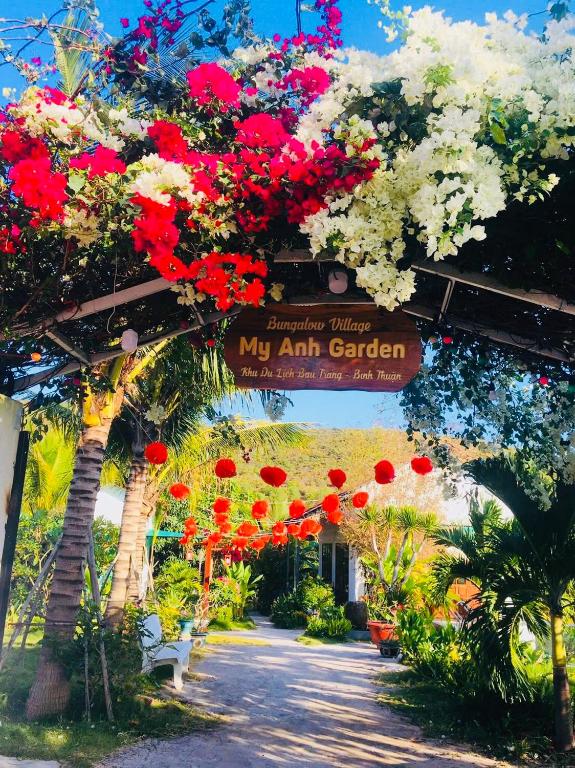 a garden with red and white flowers and a sign at My Anh Garden in Ấp Thiẹn Ái