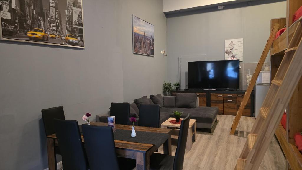 a living room with a couch and a tv at Flensburg City - 24h in Flensburg