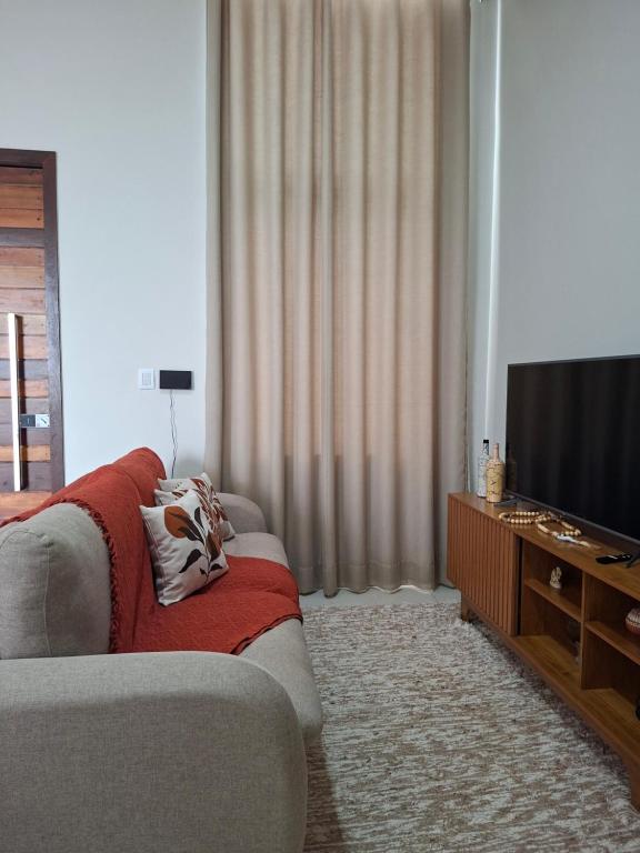 a living room with a couch and a flat screen tv at Casa Tranquila em Diamantina in Diamantina