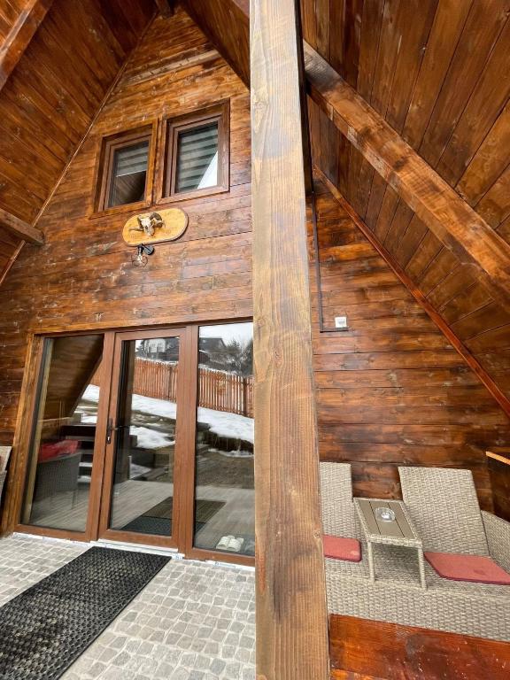 an attic room with wooden walls and a staircase in a house at Cabana De Peste Gard in Topliţa