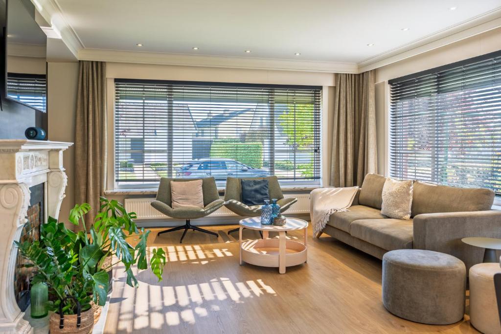 a living room with a couch and chairs and windows at roeselare stay in Roeselare