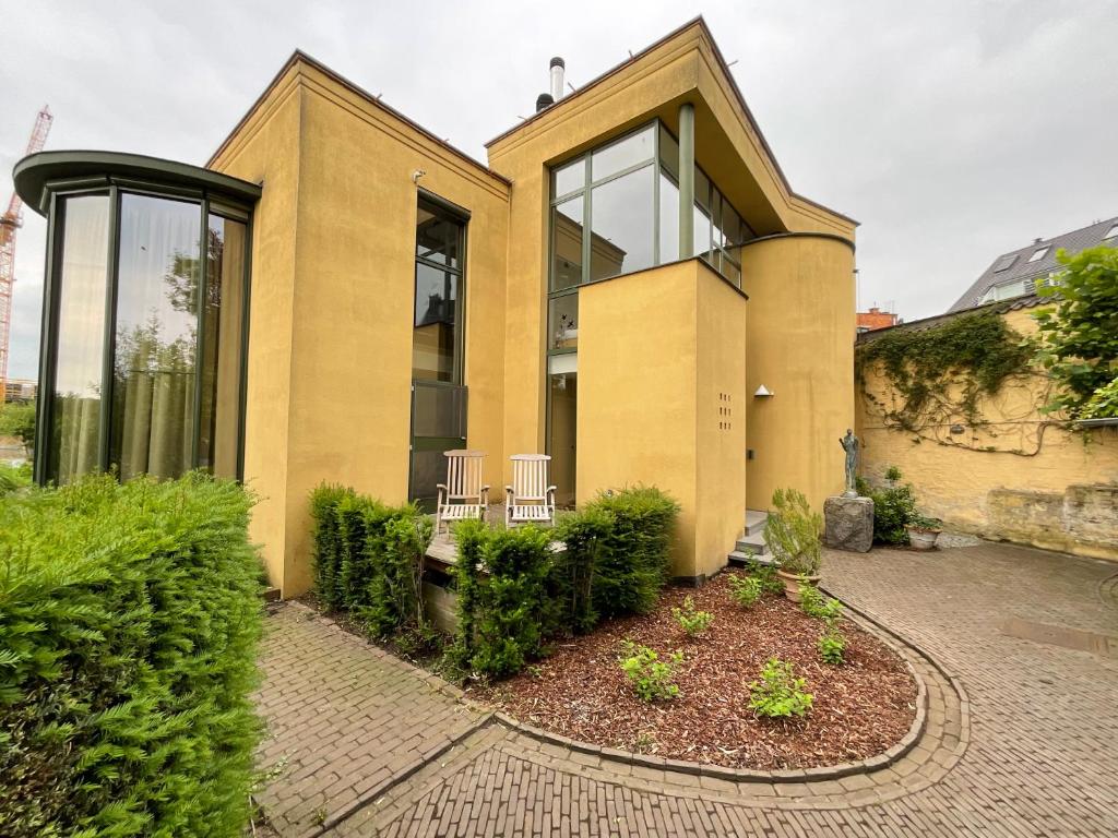 a house with two chairs in front of it at Villa Francine in Deinze
