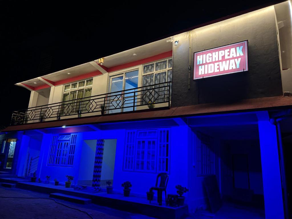 a building with a sign on the side of it at night at Highpeak Hideway Homestay in Lava