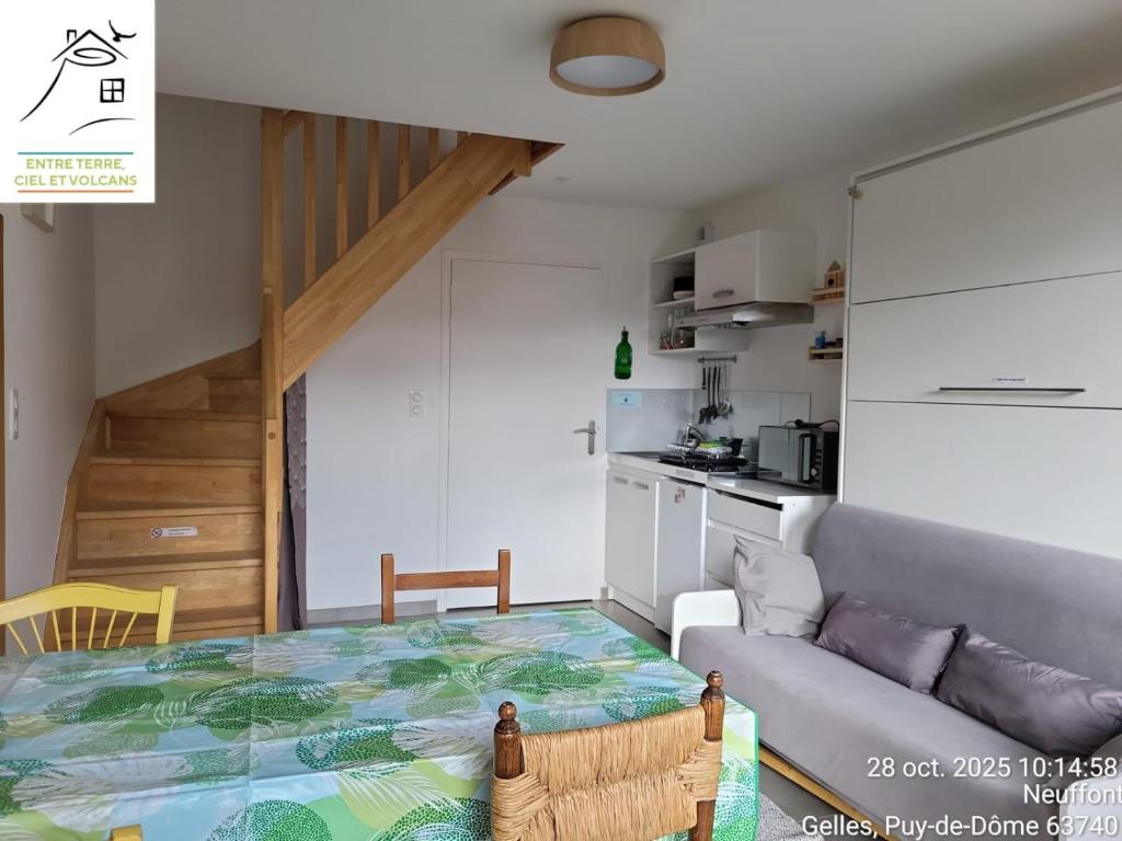 a kitchen and a living room with a table and a couch at Gîte Terre - 1-4 pers, à 20 mins de Vulcania et du Puy-de-Dôme, 35 mins du Sancy in Gelles