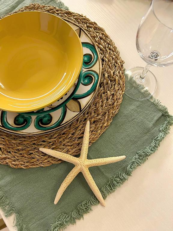 a table with a bowl and a plate and a starfish at A casa del nonno Jack in Letojanni