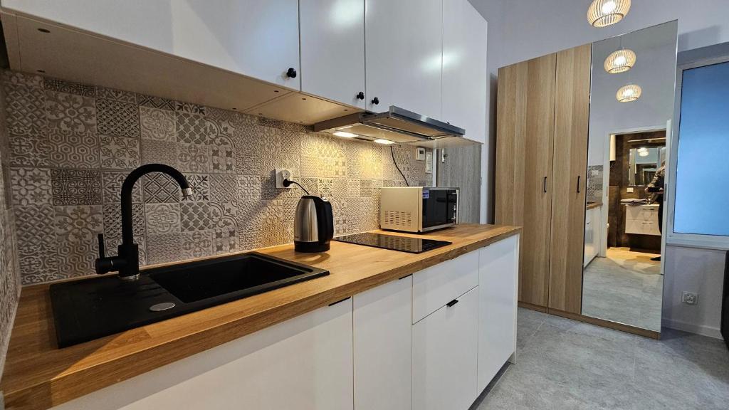 a kitchen with a sink and a microwave at Fieldorfa House in Ostrołęka