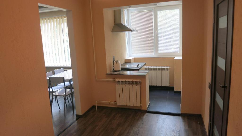 a small room with a desk and two windows at Cat Garden Superior Apartments Riga in Rīga