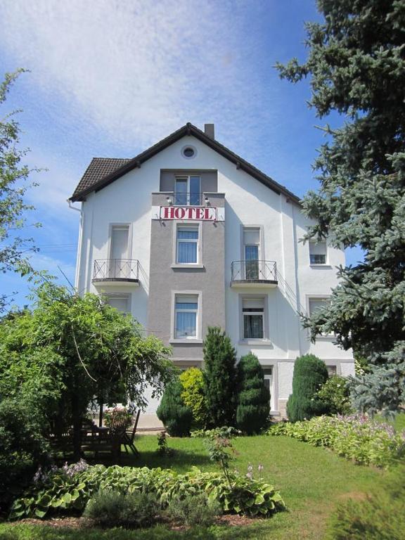 a large white building with a sign on it at Hotel W Wolfsschlucht in Baden-Baden