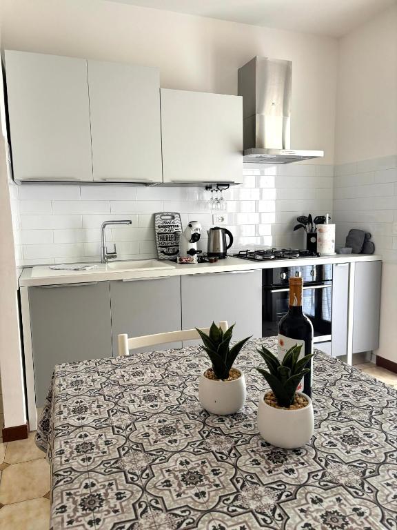 a kitchen with a table with two plants on it at Lucys Home Giardini Naxos in Giardini Naxos