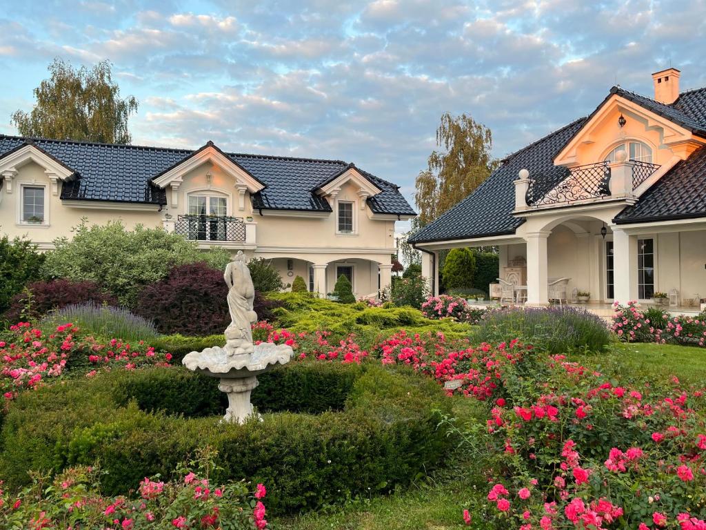 a garden in front of a house with flowers at Zielone Zacisze in Murzynowo Kościelne