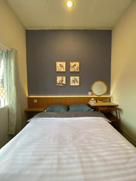 a bedroom with a large bed with a white bedspread at Rasa Jogja Homestay in Yogyakarta