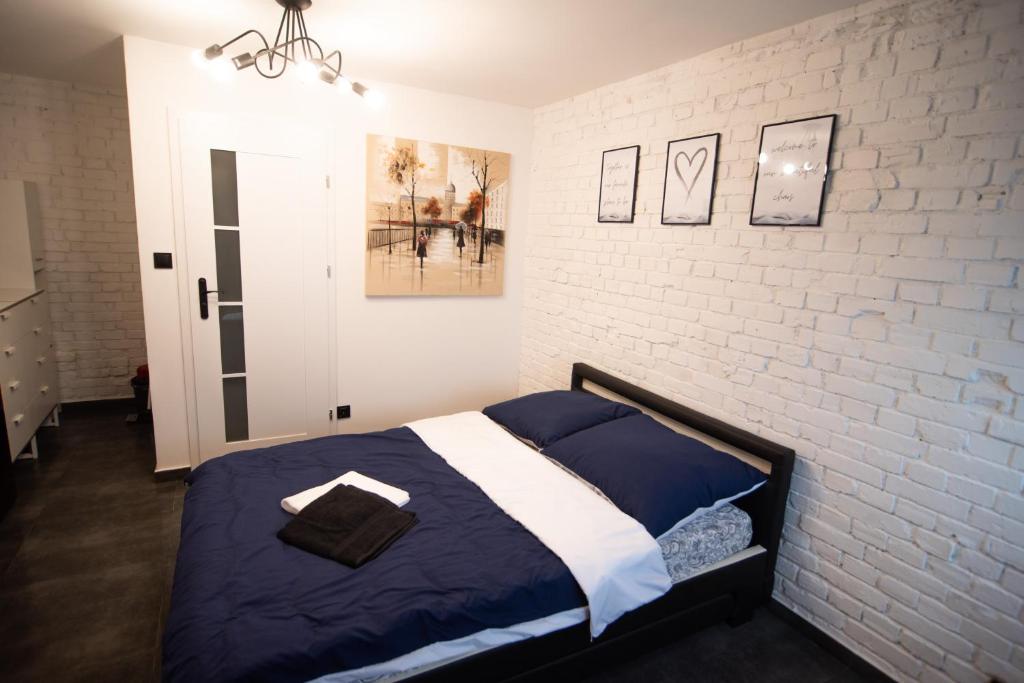 a bedroom with a bed and a white brick wall at Dream Loft in Kłodzko