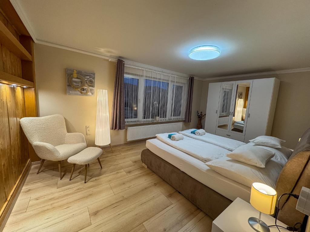 a large bedroom with a large bed and a chair at White Pearl Apartment in Murau
