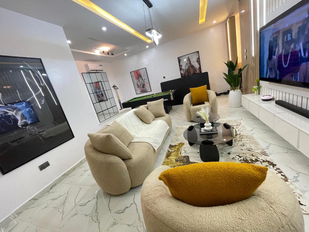 ein Wohnzimmer mit zwei Sofas und einem Fernseher in der Unterkunft 2-Bedroom Apartment with Pool, Gym, Snooker & Table Tennis in Lekki Ajah in Lekki