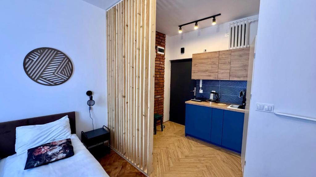 a small room with a bed and a kitchen at Wolność in Elblag