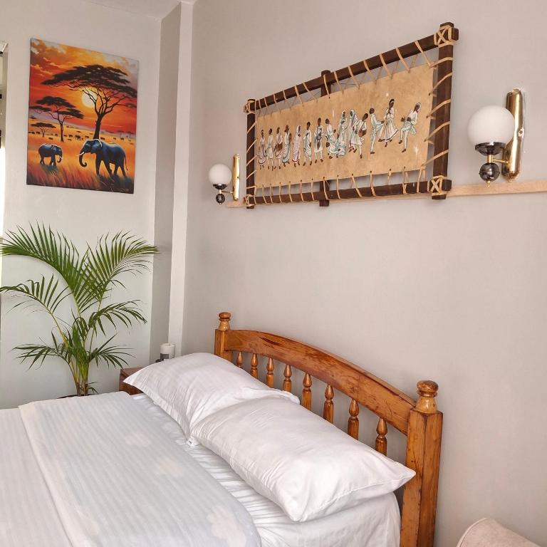 a bedroom with a bed and a painting on the wall at Spacious Studio Apartment with Swimming pool in Nairobi