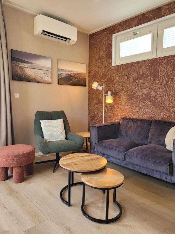 a living room with a couch and two chairs and a table at Vakantiehuis Huisje 31 Zoutelande in Zoutelande