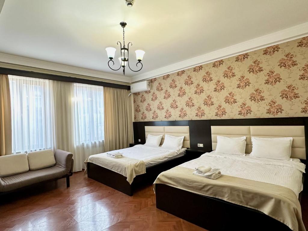 a hotel room with two beds and a couch at Four brother in Tbilisi City