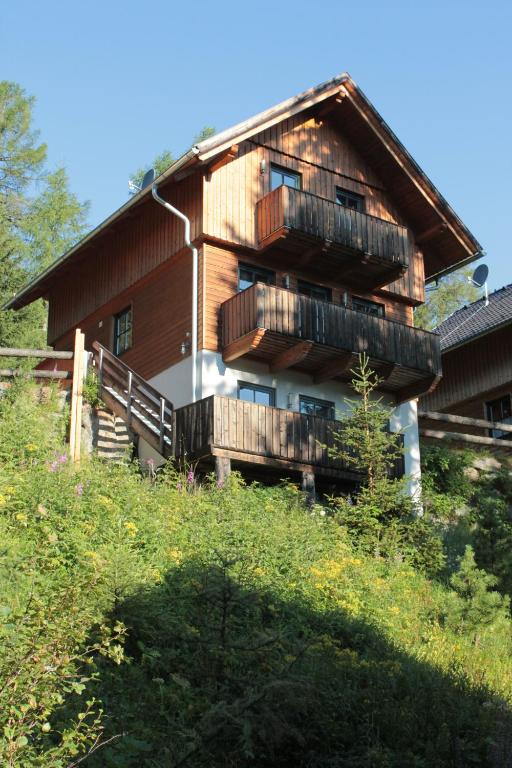 a wooden house with balconies on top of a hill at Turracher Berghütte in Turracher Hohe