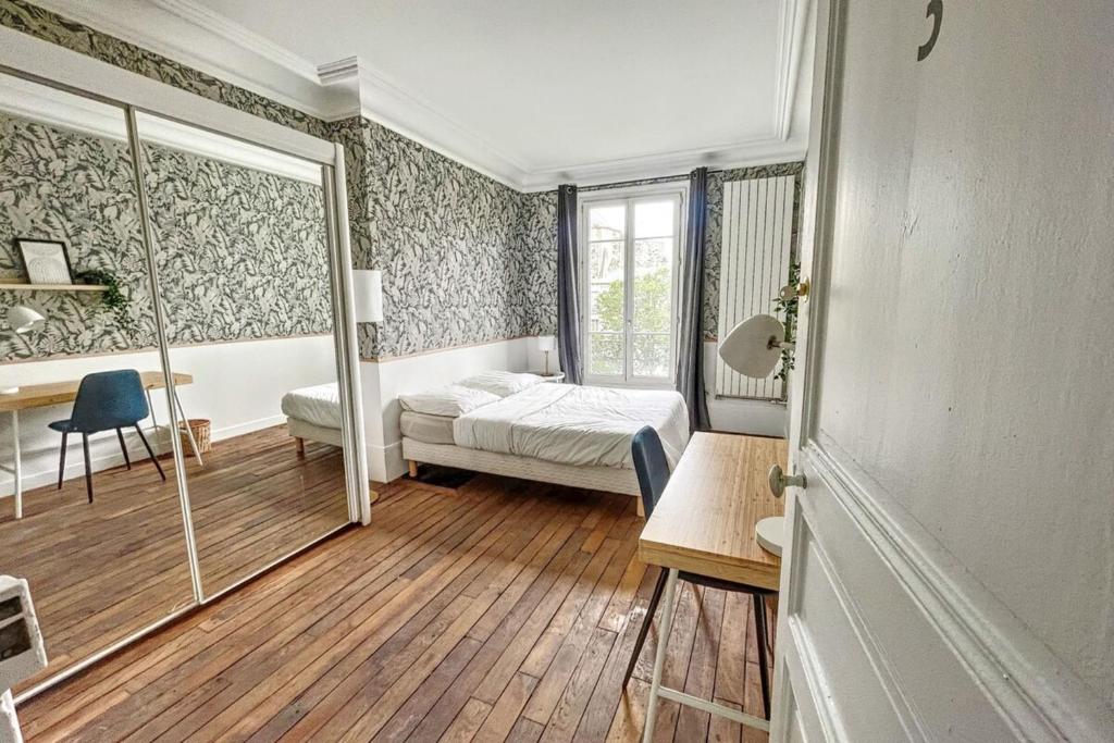 a bedroom with a bed and a desk and a window at Room in elegant 3-bedroom apartment near Bois de Vincennes in Paris