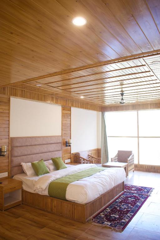 a bedroom with a large bed in a wooden room at Vezara homestay in Kūfrī