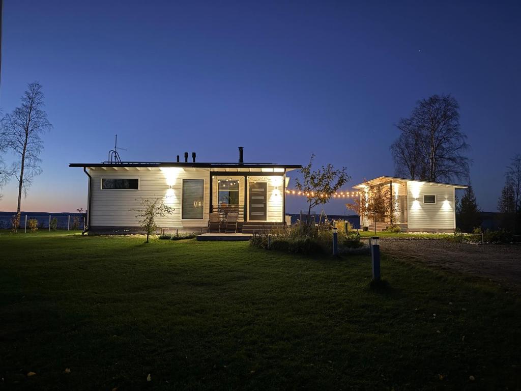a house with lights on it in a yard at Willa Koivuranta Kajaani in Pikkuhannus