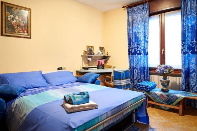 una camera con letto blu e tende blu di B&B il Patio a Bergamo