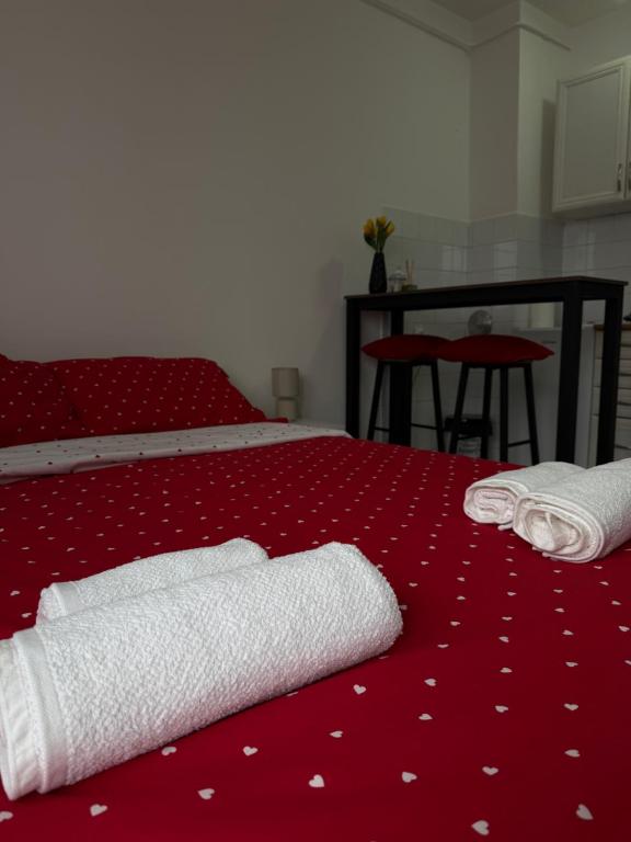 a red bed with two towels on top of it at AG Apartman in Kraljevo