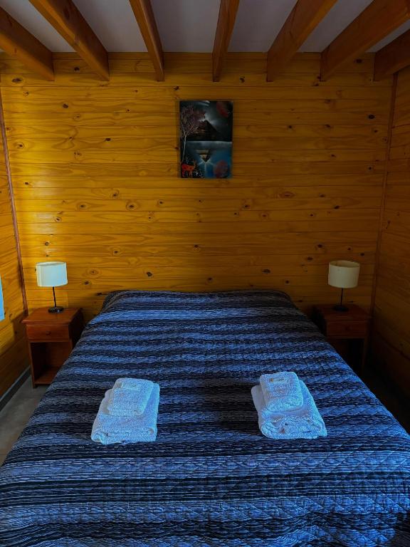 a bedroom with a bed with two towels on it at Depto Castillo in El Bolsón