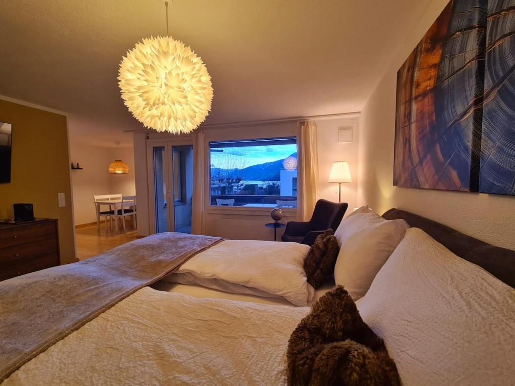 a bedroom with a large bed and a chandelier at Fli Apartment in Weesen