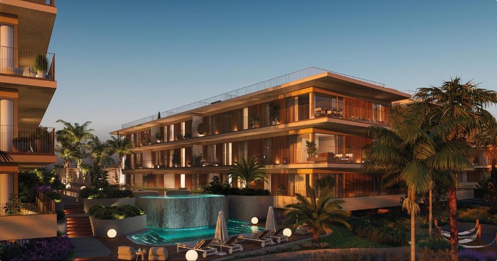 an apartment building with a swimming pool and palm trees at Sweet Horizon in Quarteira