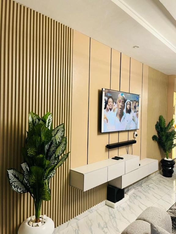 a living room with a tv on a wall at OS Dominion Homes in Mama