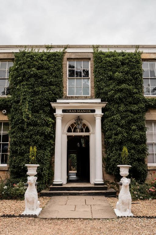 an entrance to a building with a large ivy at Crab Manor Hotel in Thirsk