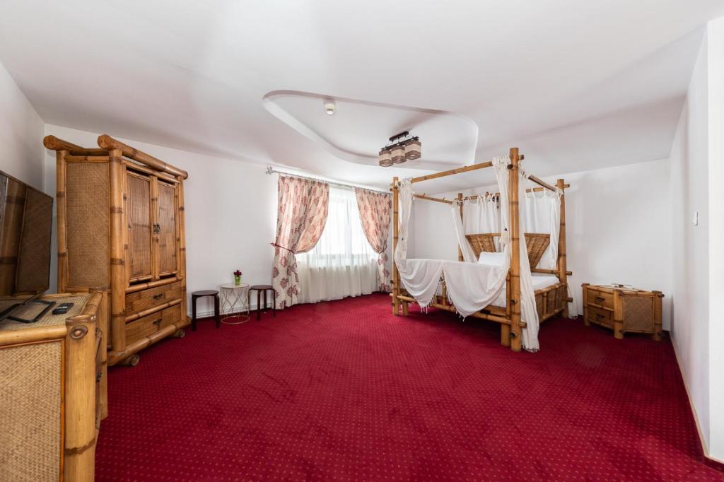a bedroom with a bed and a red carpet at Pensiunea Rosenau in Râşnov