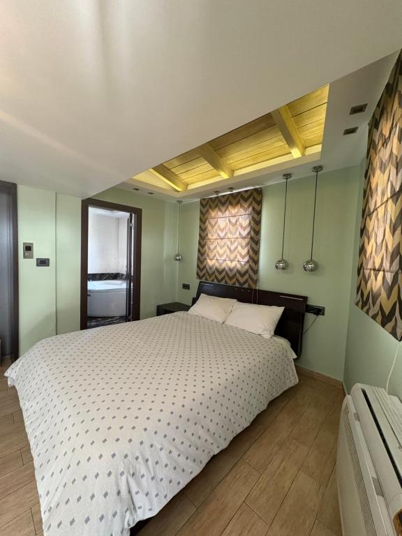 a bedroom with a large white bed and a window at Uplift Hideaway Jacuzzi in Patra