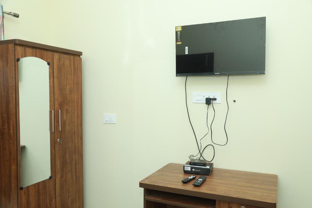 a flat screen tv hanging on a wall at serene cottage in Yelagiri