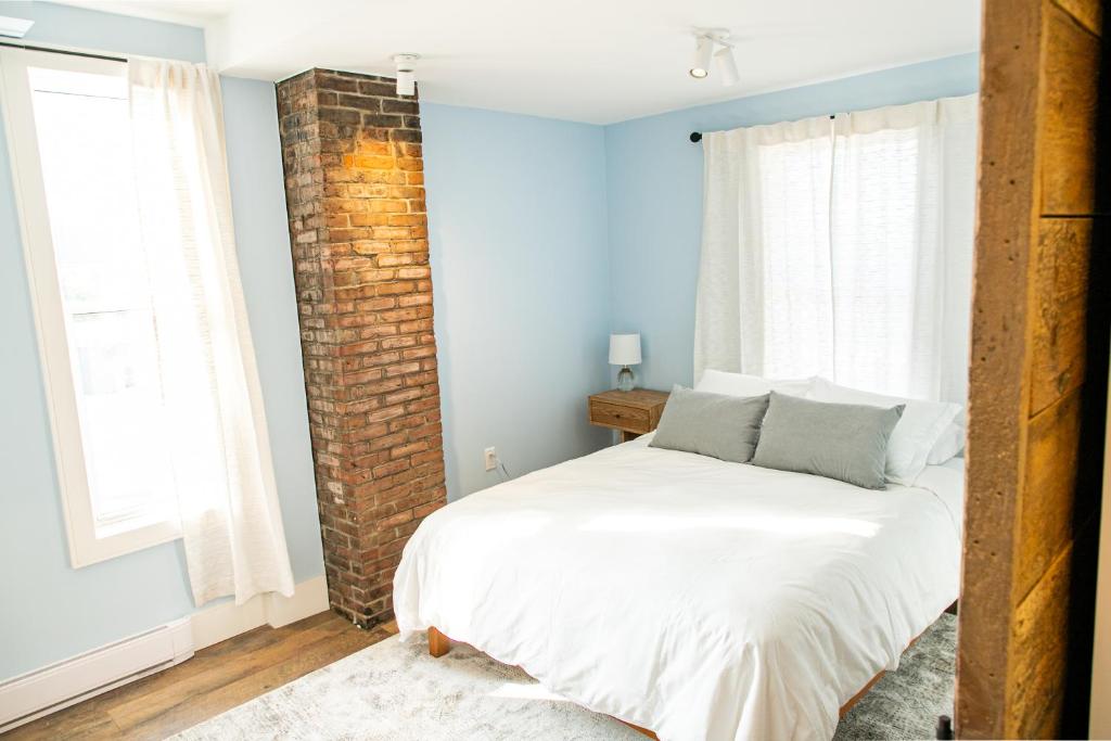 a bedroom with a bed and a brick wall at Halifax's Most Popular Historic Modern Space in Halifax
