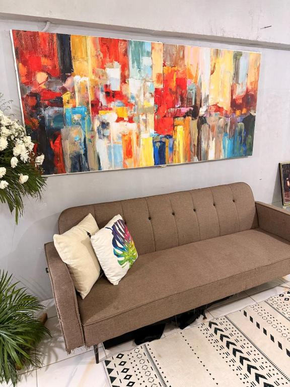 a couch in a room with a painting on the wall at Manzanares Homestay in San Jose
