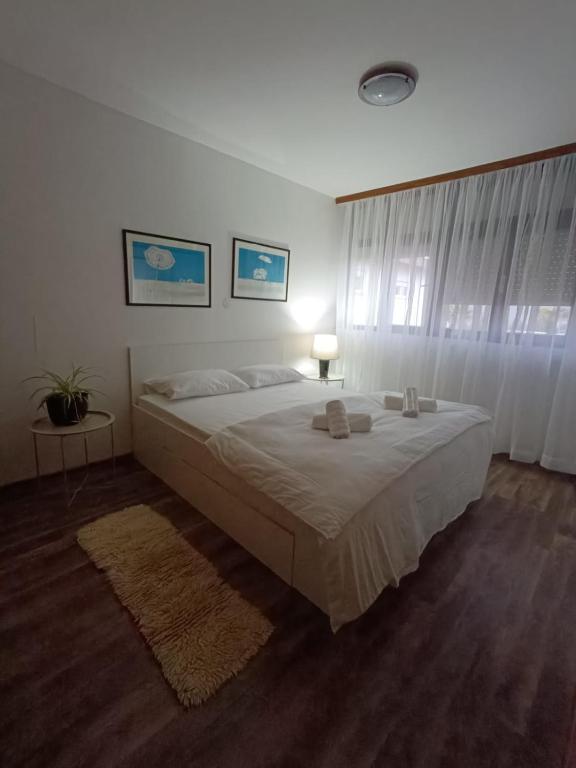 a bedroom with a large white bed and a window at Apartman Centar in Grude