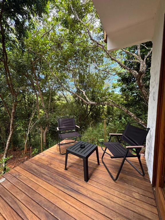 two chairs and a table on a wooden deck at CASA NANDOS Studio quintal da mata !!! in Itacaré