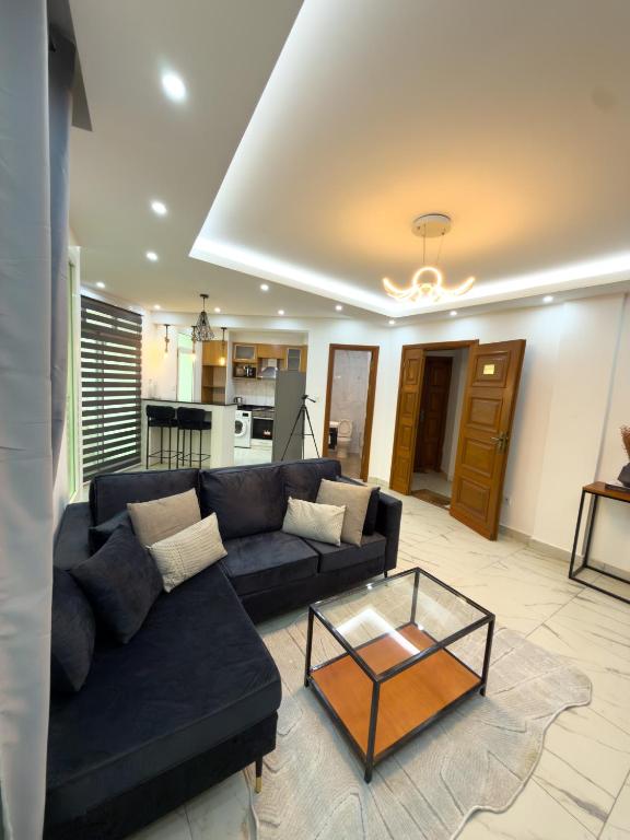 a living room with a couch and a coffee table at Bel appartement a Yaoundé Bastos in Yaoundé