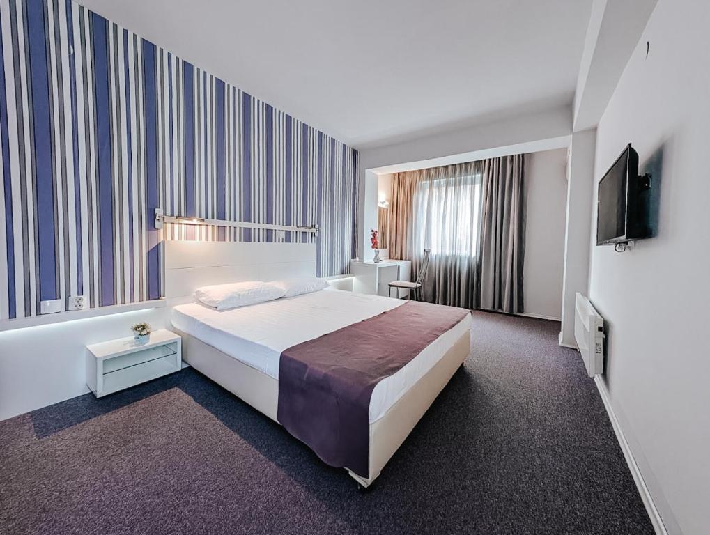 a hotel room with a bed and a television at Violet Stay in Skopje