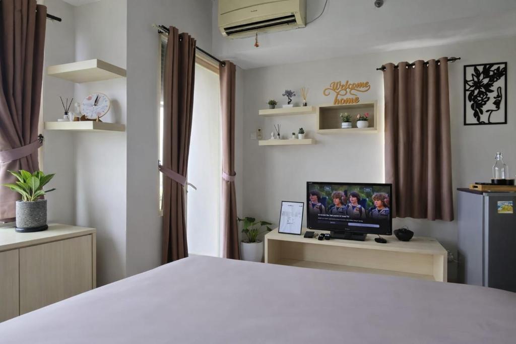 a bedroom with a bed and a tv on a desk at Soft Reset Room by YOMAIN in Kemirimuka Tiga
