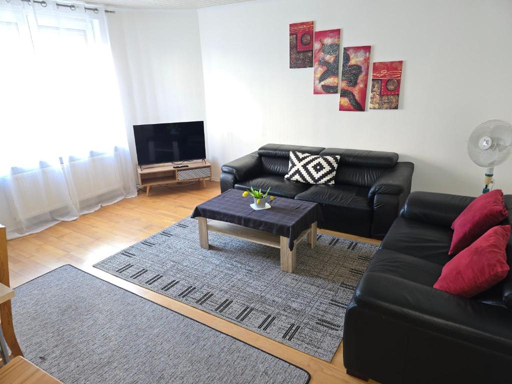 a living room with a black couch and a table at Apartments bei Marienplatz in Stuttgart